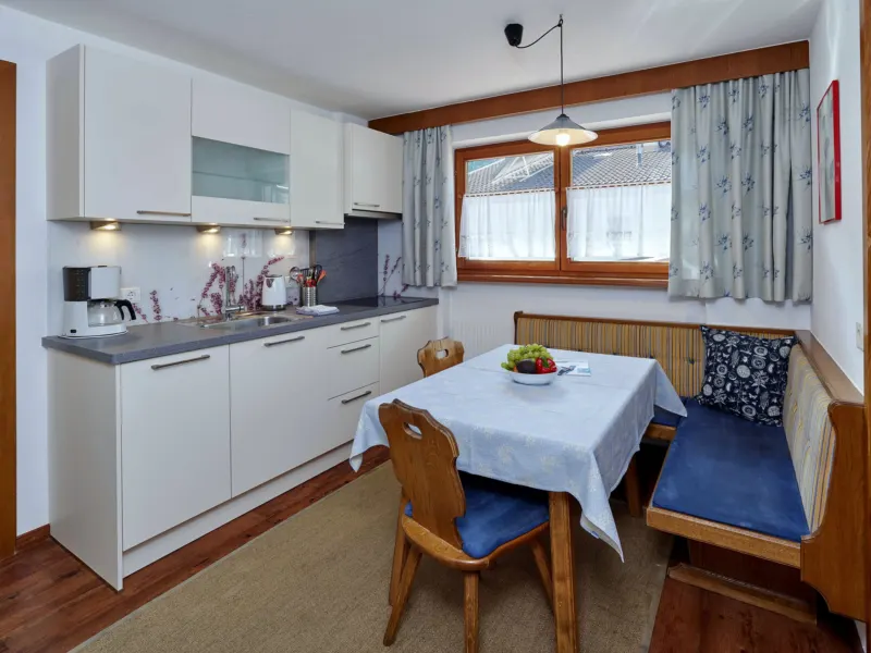 Küche mit Esstisch am Fenster im Appartement Nederkogel