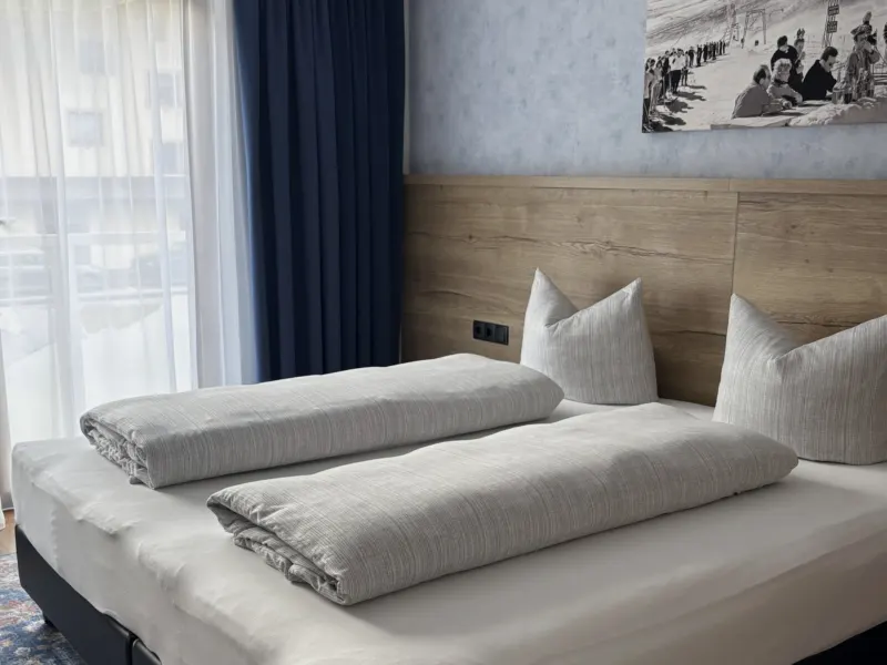 Schlafzimmer mit Doppelbett vor dem Fenster im Appartement Nederkogel
