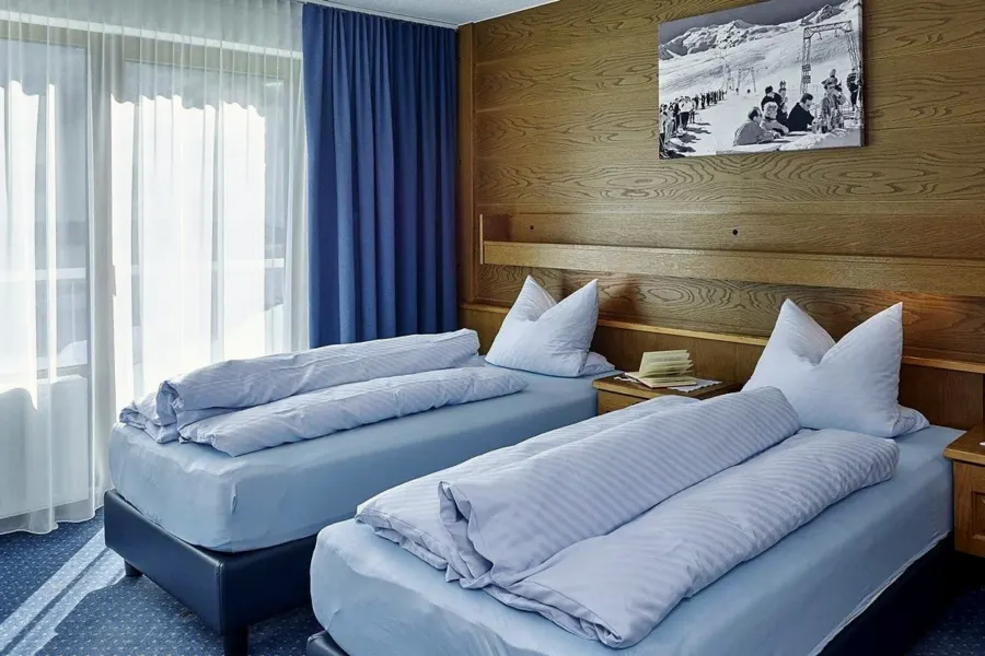 Schlafzimmer mit Doppelbett und Holzvertäfelung