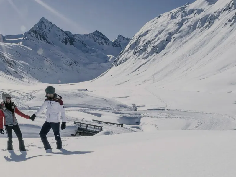Winterwanderer auf einem geräumten Weg im Schnee