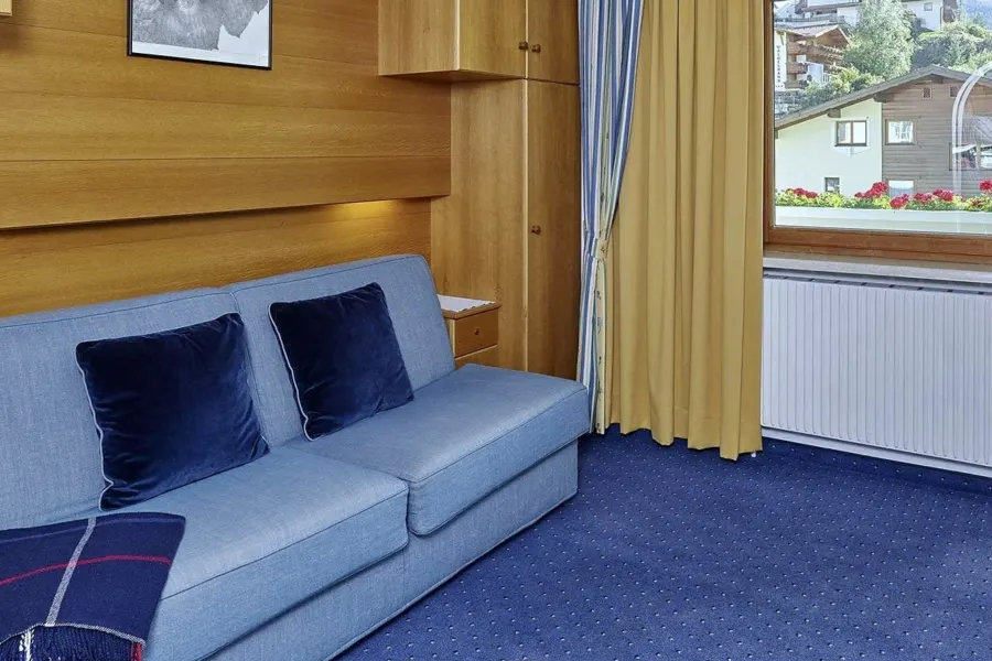Wohnraum mit Sofa, Essbereich und Balkontür