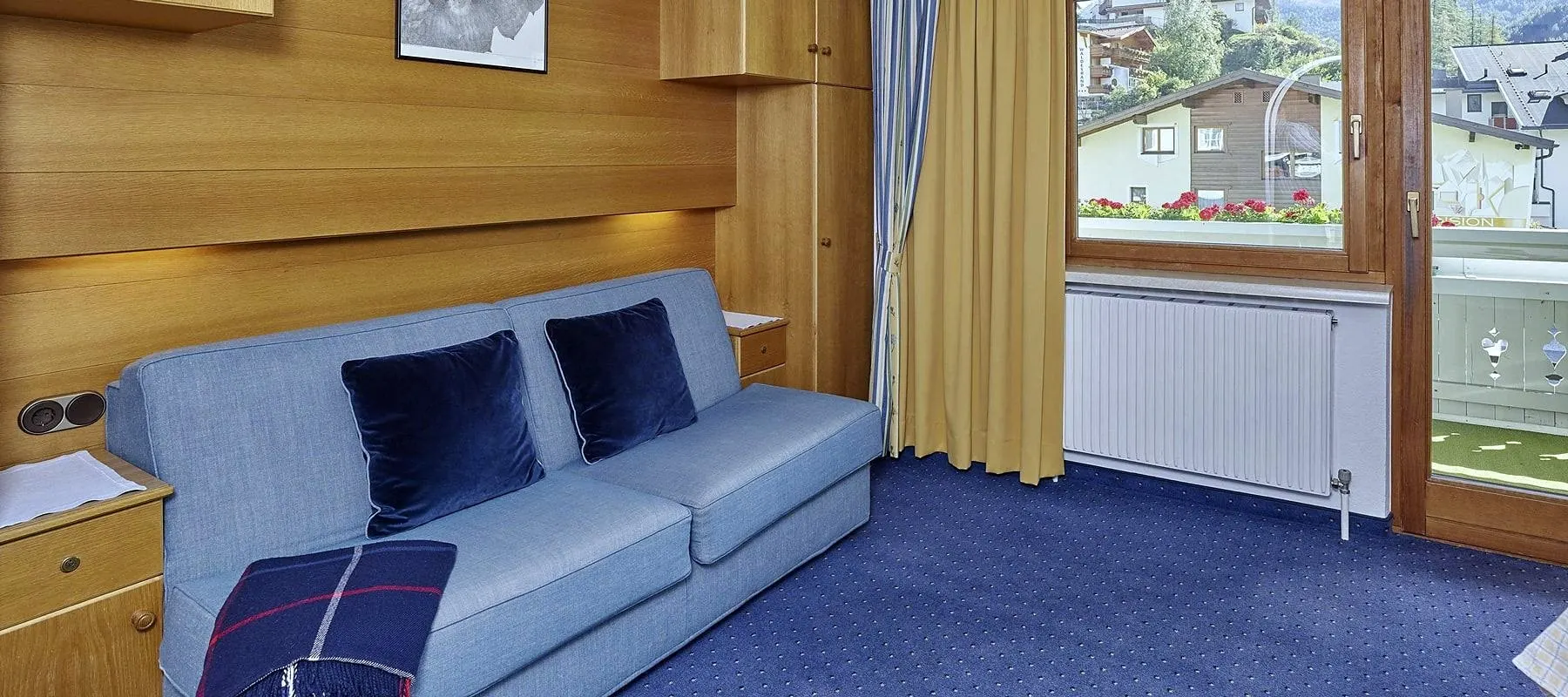 Wohnraum mit Sofa, Essbereich und Balkontür