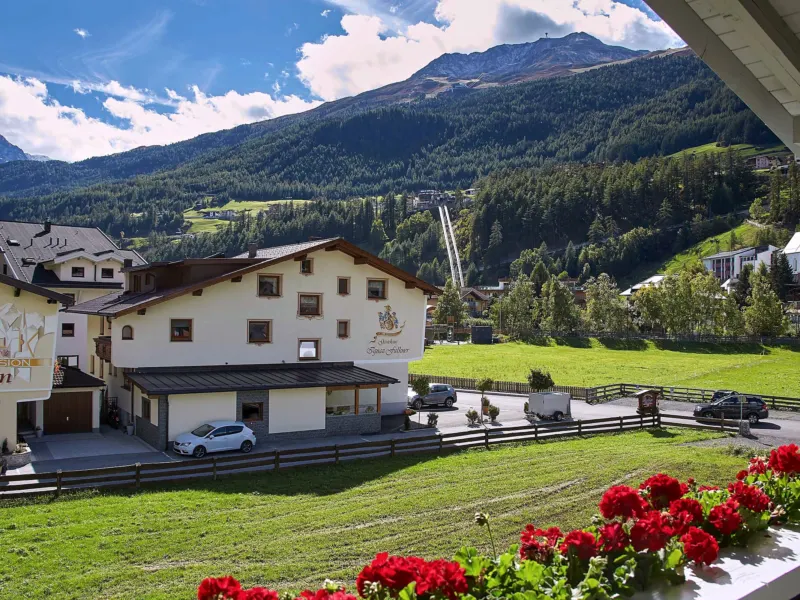 Blick vom Balkon mit Geranien über Sölden auf die Berge