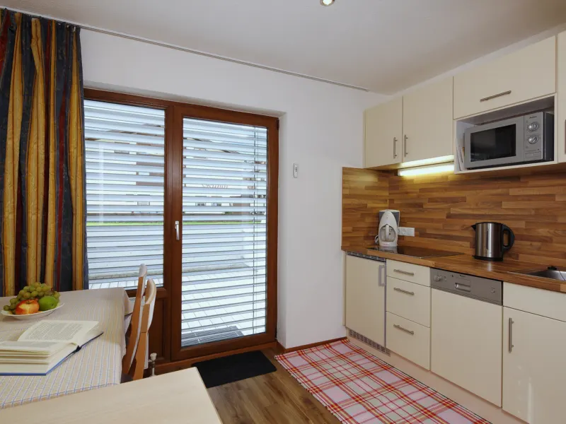 Küche mit Mikrowelle und Essplatz an der Balkontür im Appartement Brunnenkogel