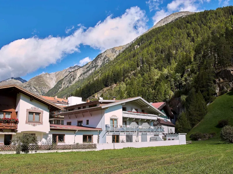 Das Haus Kristiania im Sommer zwischen den Nachbarhäusern von Sölden