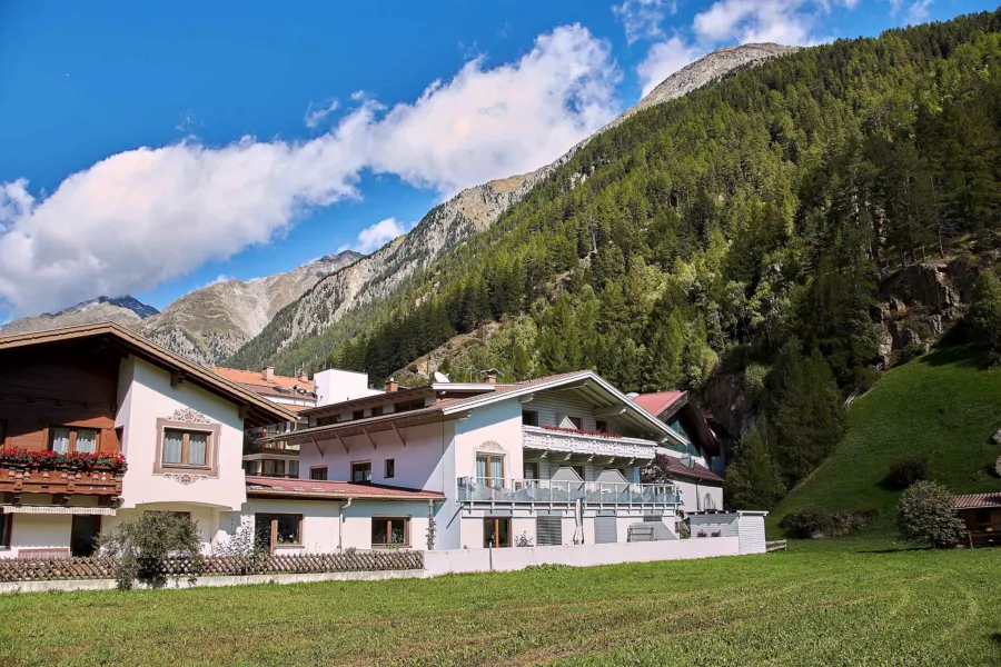 Das Haus Kristiania im Sommer zwischen den Nachbarhäusern von Sölden