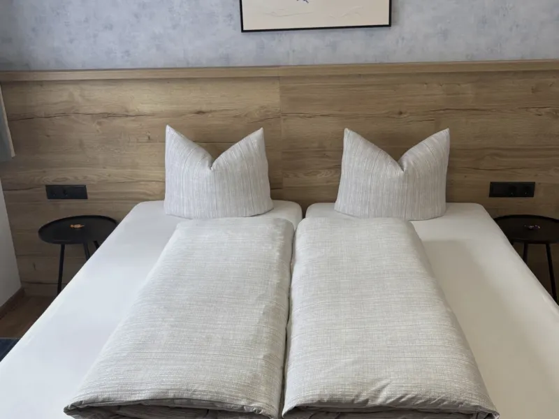 Schlafzimmer mit Doppelbett und Beistelltisch im Appartement Nederkogel