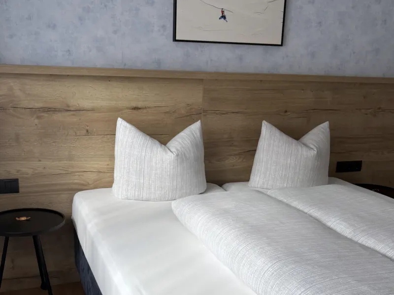 Schlafzimmer mit Doppelbett und Hocker im Appartement Nederkogel