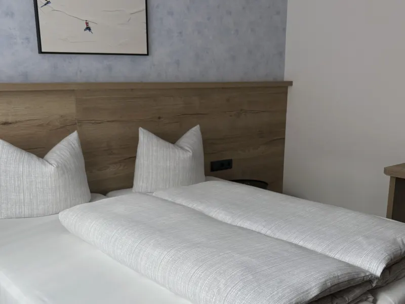 Schlafzimmer mit Doppelbett und Stuhl im Appartement Nederkogel